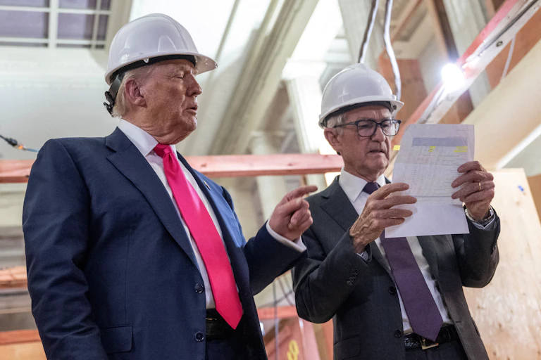 Two men in hard hats chart and look at a piece of paper.