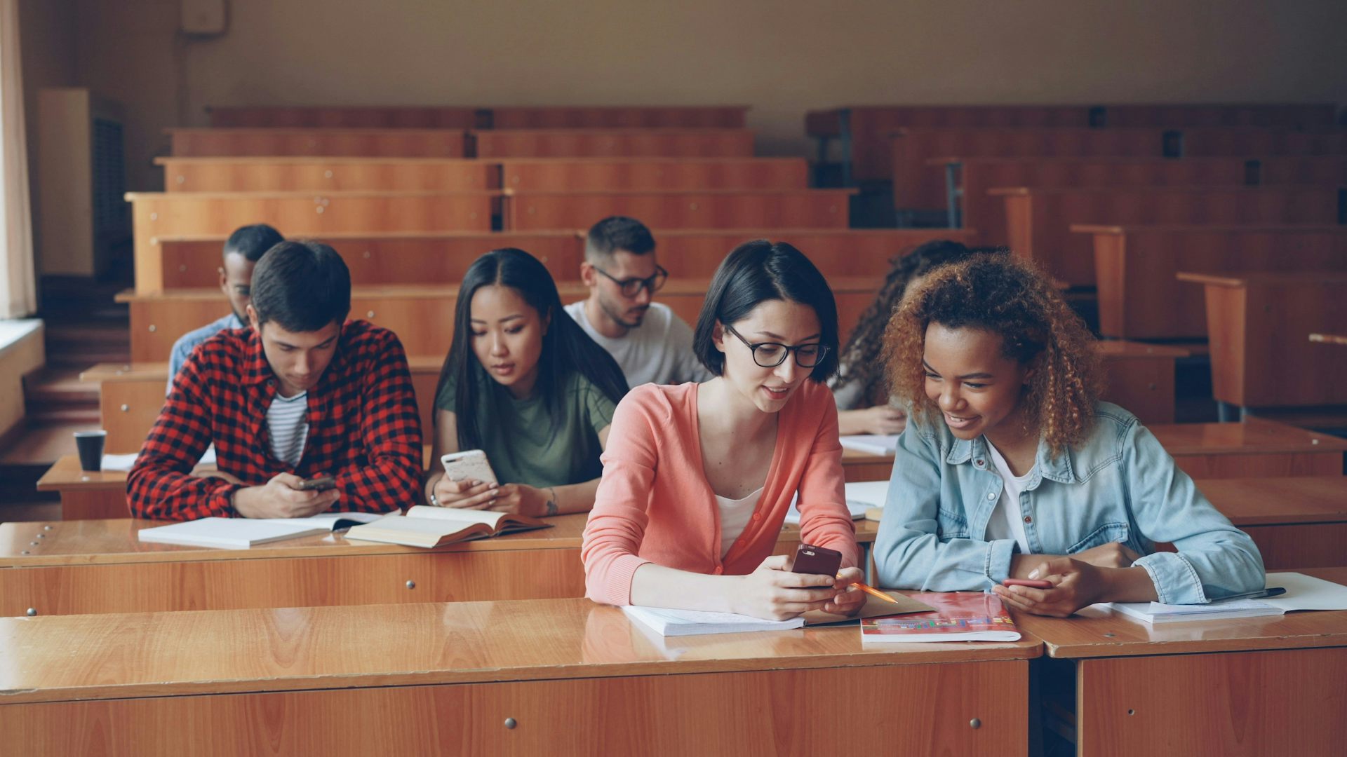 Un grupo de estudiantes sentados y trabajando juntos en clase.