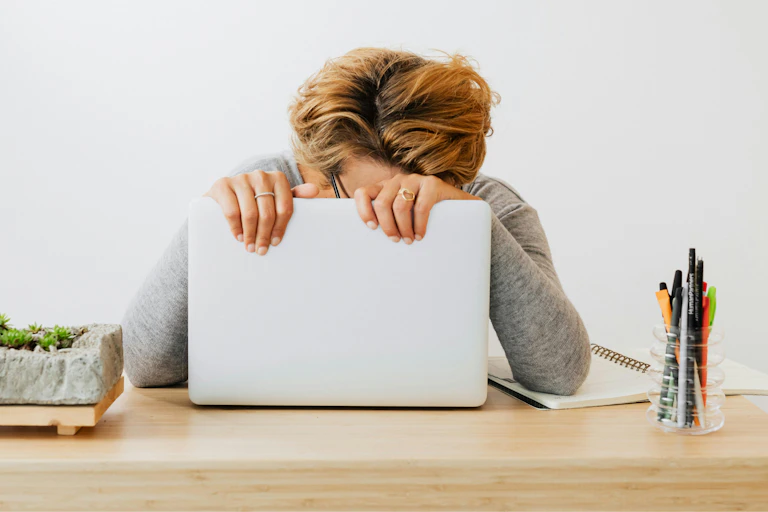 A woman slumps against her computer.