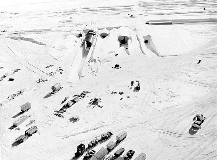 Trucks are parked outside the partially buried Camp Century.