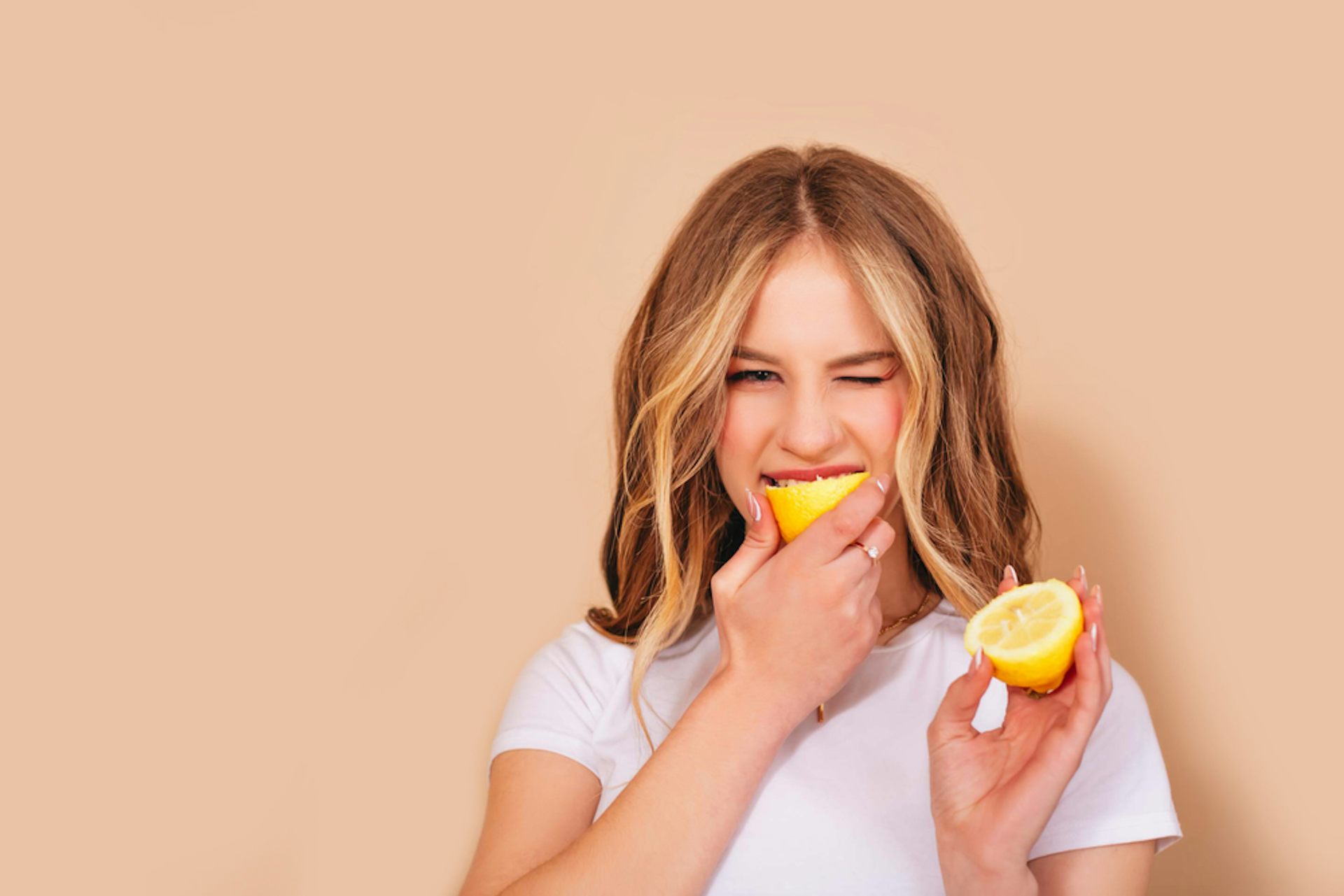 Woman biting into a lemon.