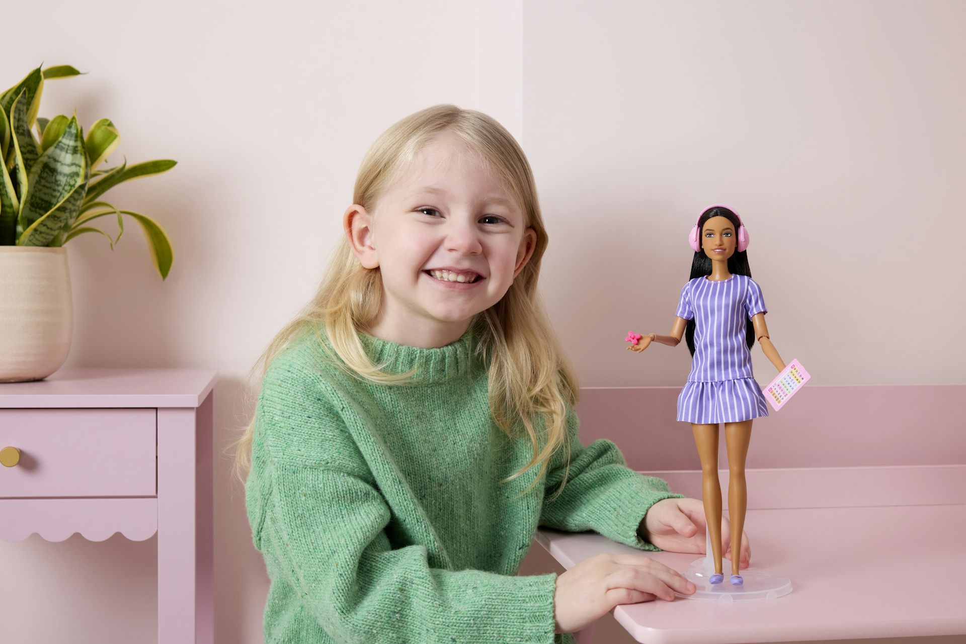 Small blonde child with autistic Barbie