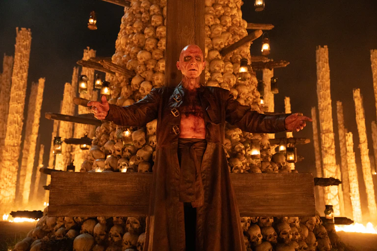 Fiennes in front of a alter made of bones