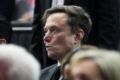 A dark-haired man in a crowd.