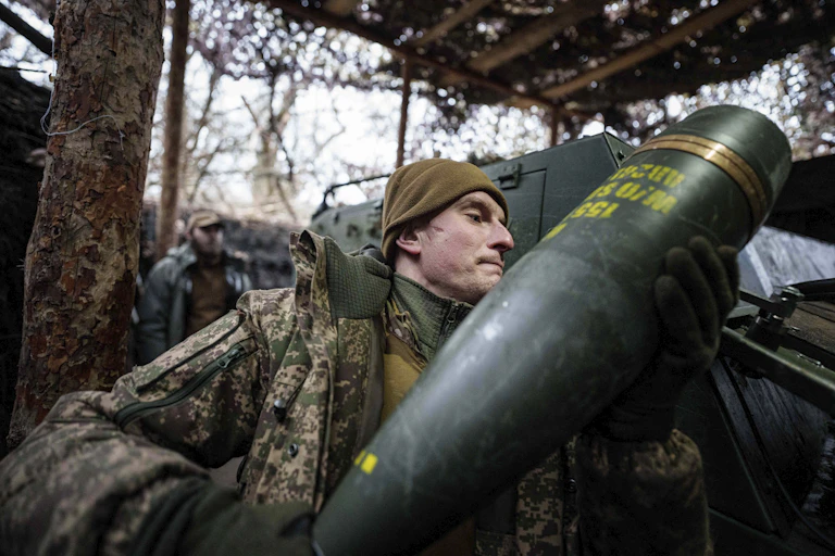 Un soldat arme un obusier