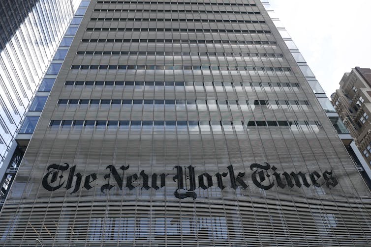 A large building with the words 'The New York Times' emblazoned on its lower floors.