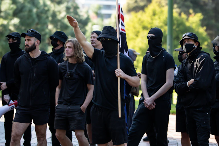 Neo-Nazi members performing a Nazi salute during a protest opposing immigration at Fitzroy Garden in Melbourne.