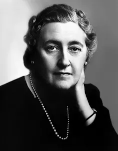 A black and white image of a sombre-looking Agatha Christie dressed in black.