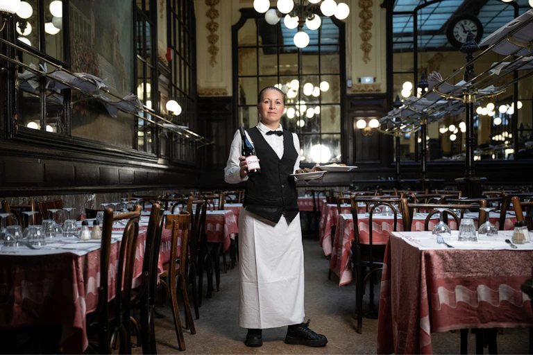 Head waitress Fati at Bouillon Chartier, strikes a pose in the main dining room of this Parisian institution.