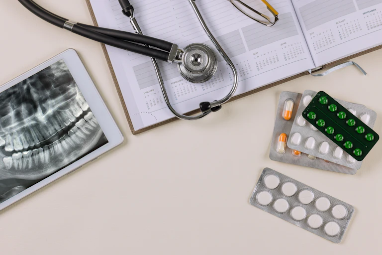 Des plaquettes de pilules et un stéthoscope sur une table.