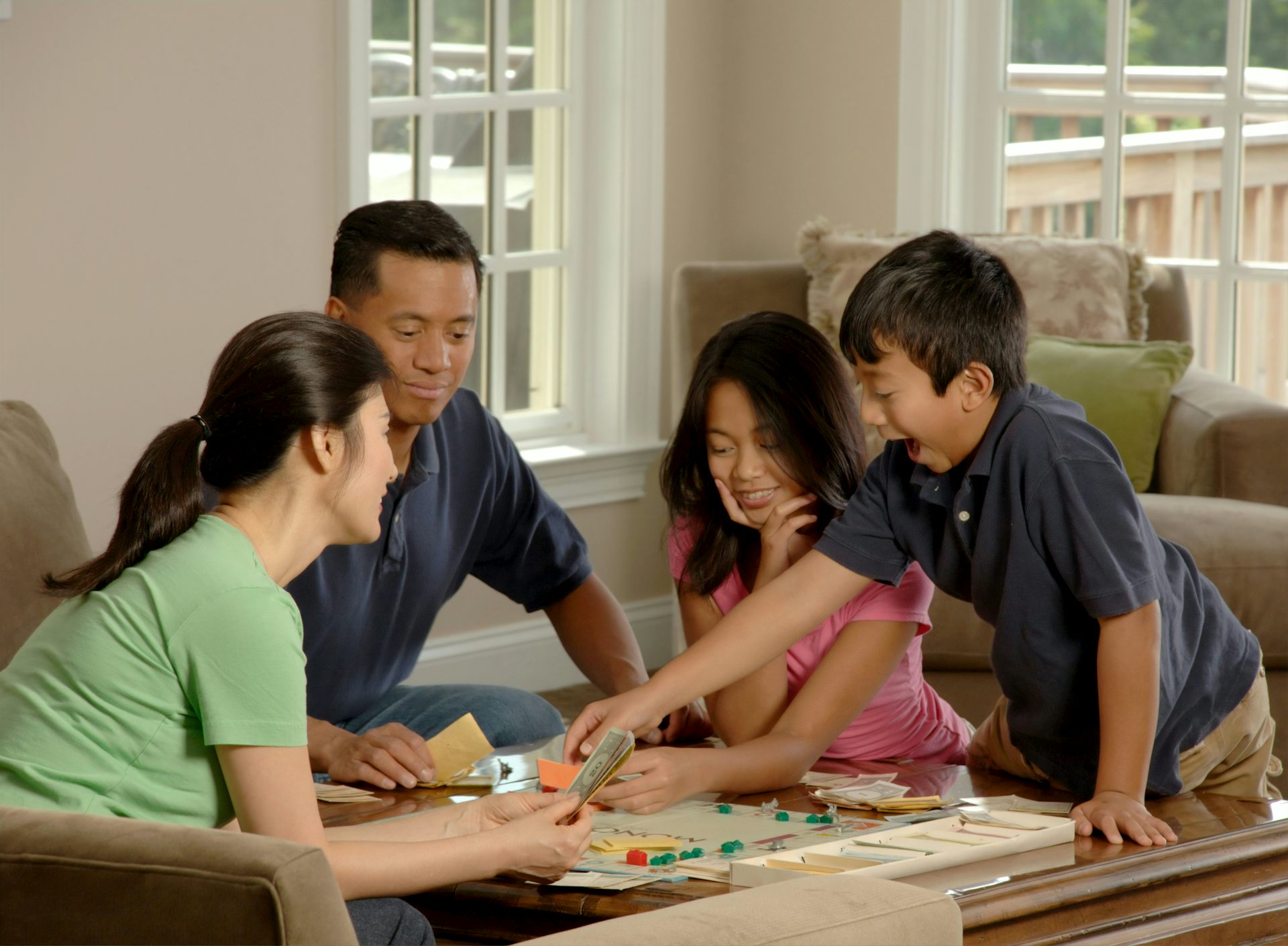Family playing monopoly at home.