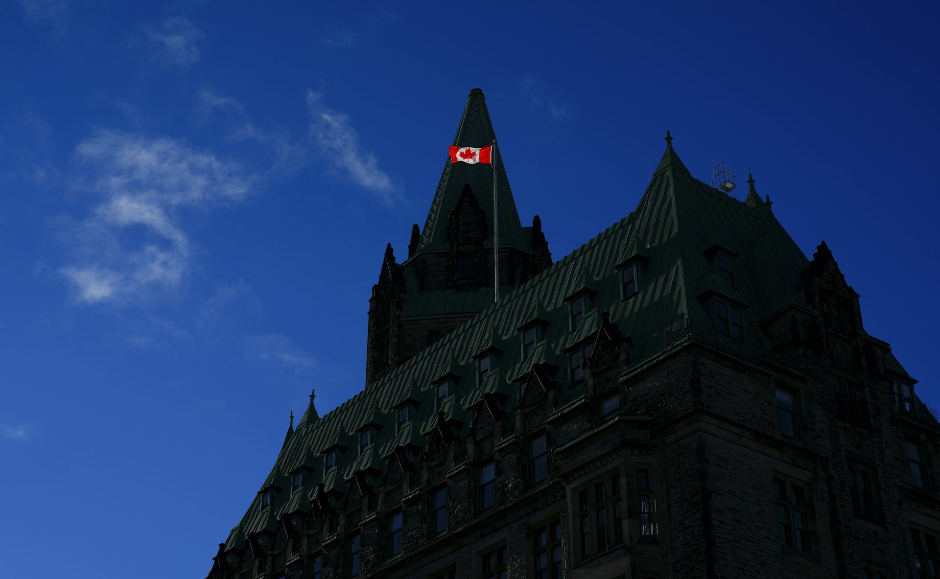 A Canada flag atop the Justice building on Parliament Hill catches the morning light.