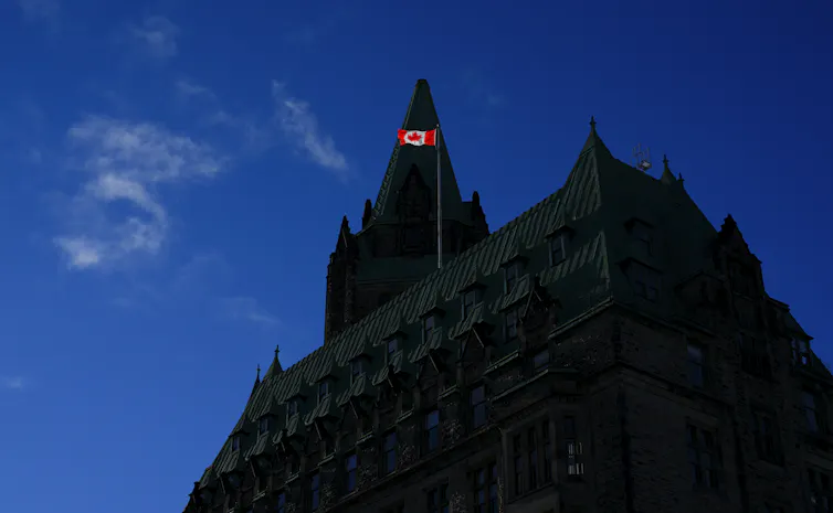 La bandera canadiense en lo alto del edificio de Justicia en la Colina del Parlamento capta la luz de la mañana.