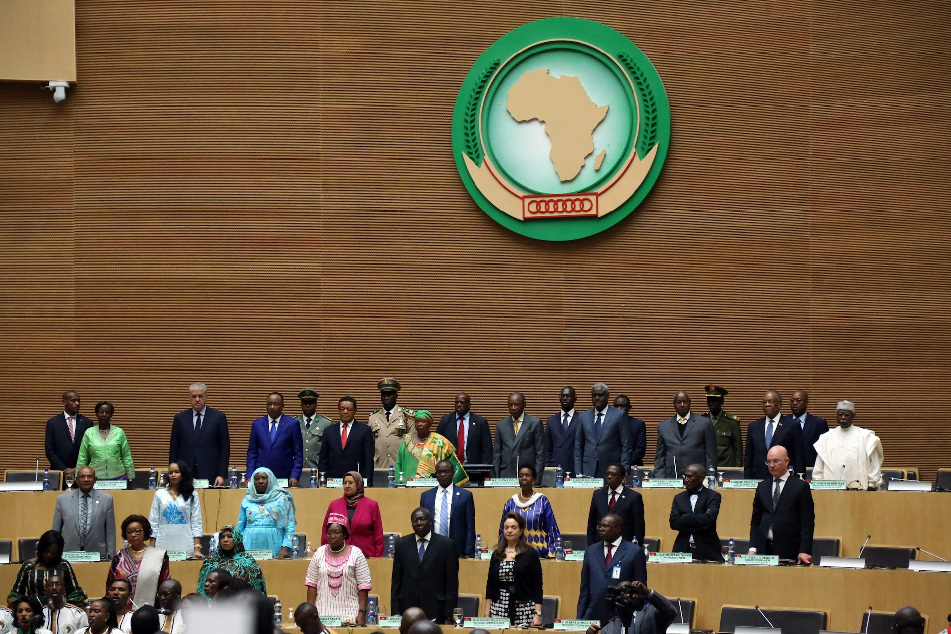 Men and women standing in a conference setting with an Africa logo on the wall