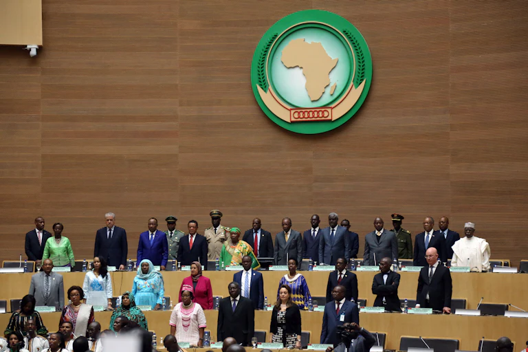Men and women standing in a conference setting with an Africa logo on the wall