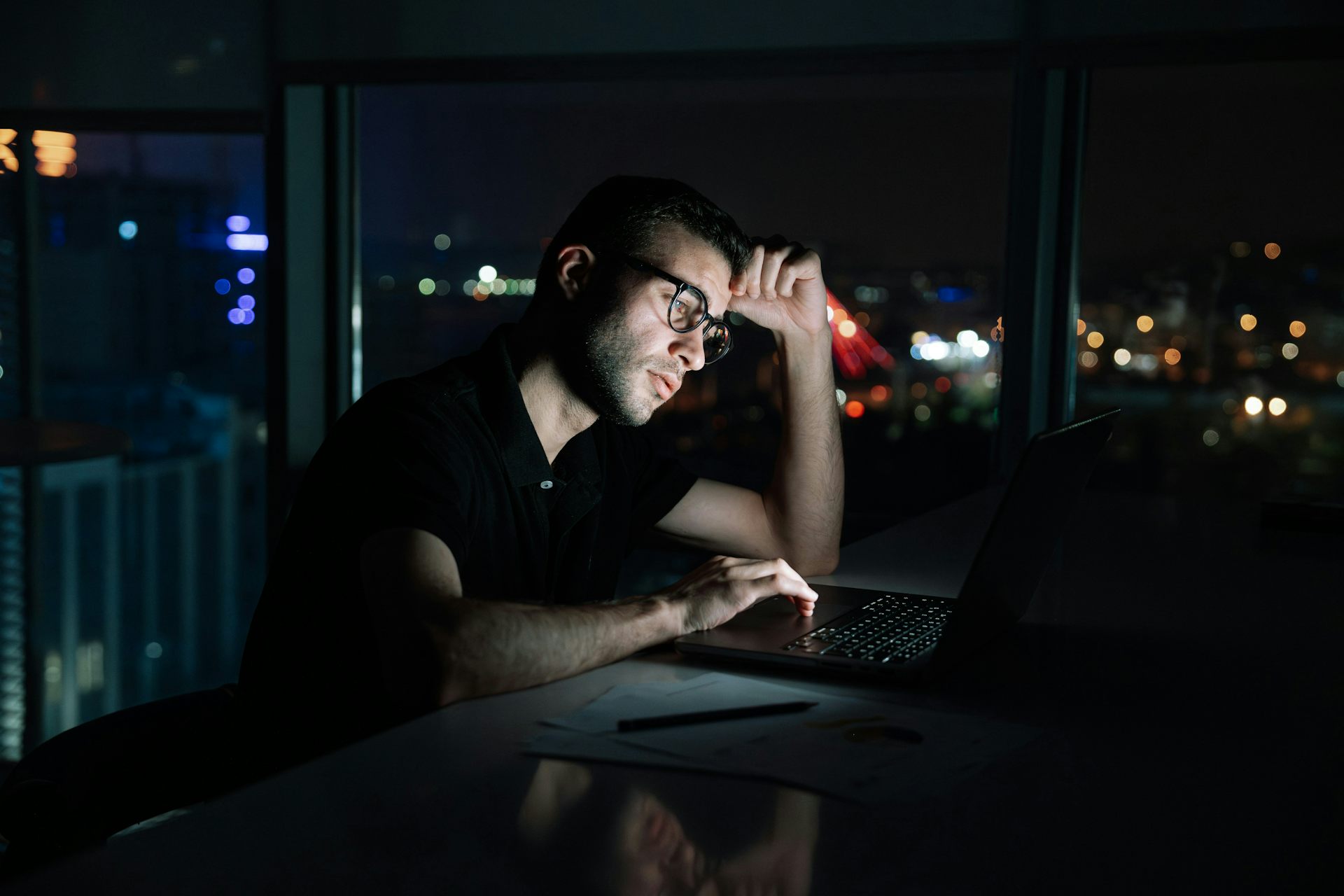 El hombre sentado en este escritorio frente a su computadora.