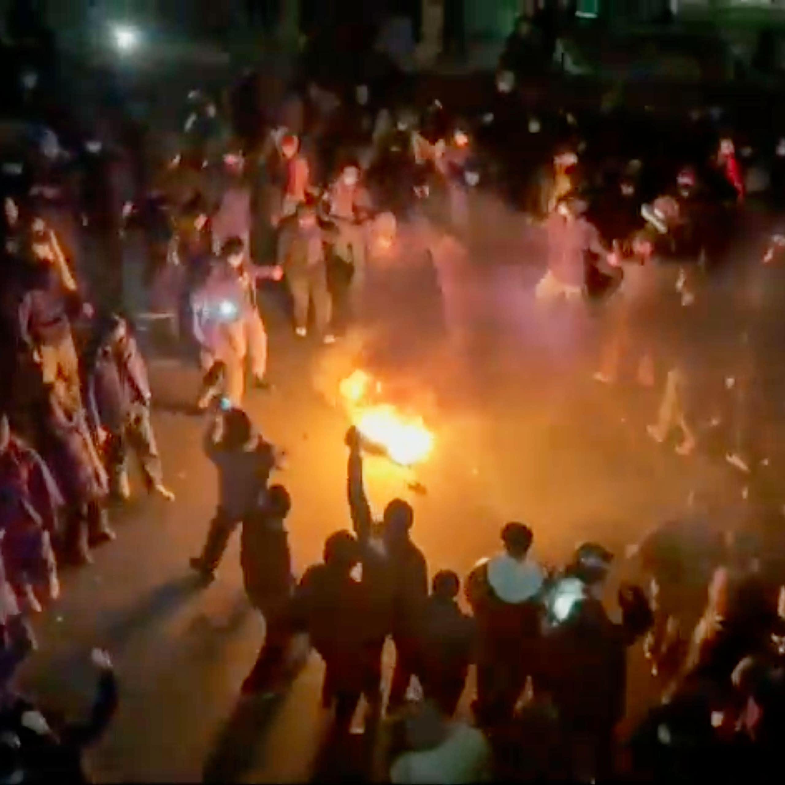 Protesters gather round a bonfire in central Tehran.