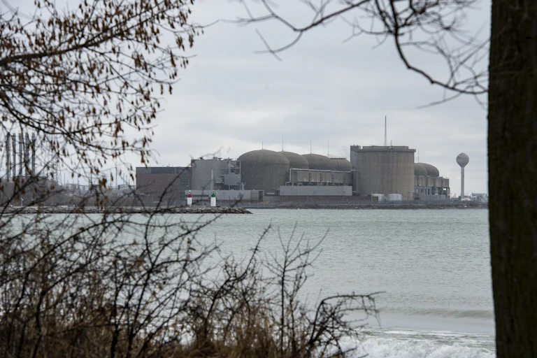 A group of large grey concrete structures near the banks of a body of water