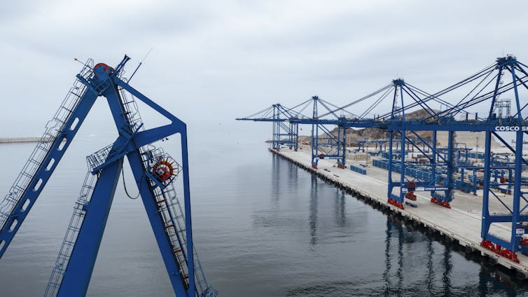 En el muelle se puede ver una hilera de grúas.