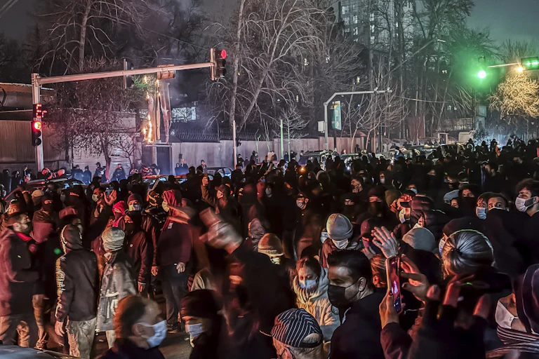 a crowd fills a city intersection at night