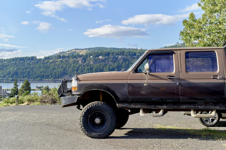 A car with a bullbar is parked on a road.
