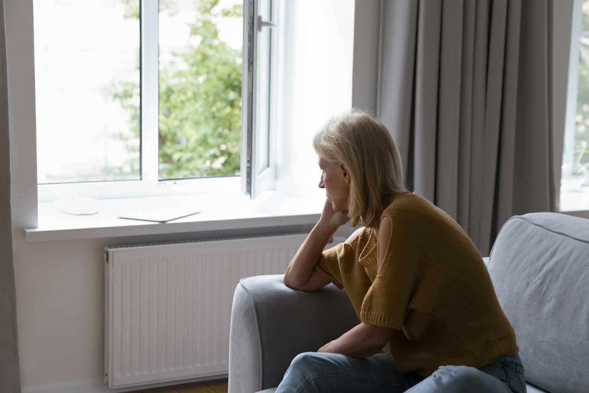 A depressed woman staring out of a window.