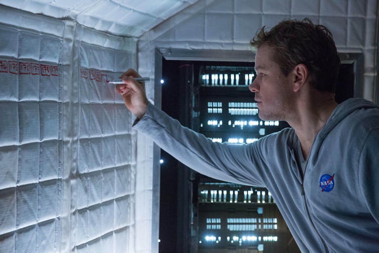 A still of Matt Damon writing on a wall from The Martian