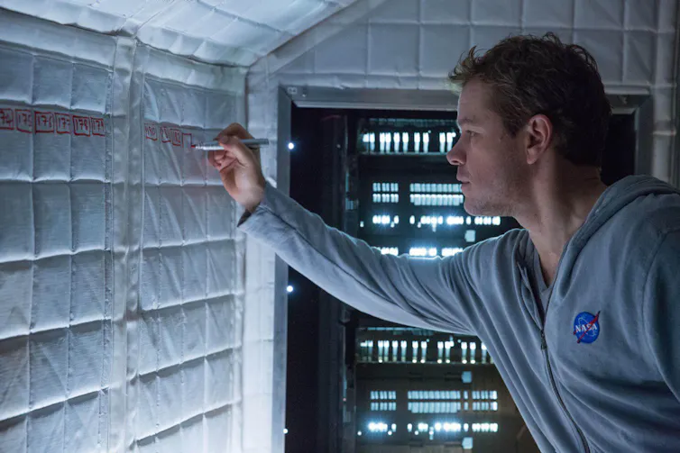 A still of Matt Damon writing on a wall from The Martian