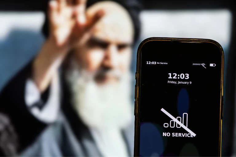 A composite picture showing Iran's supreme leader Ali Khamenei with a smartphone in the foreground with a message about an internet outage.