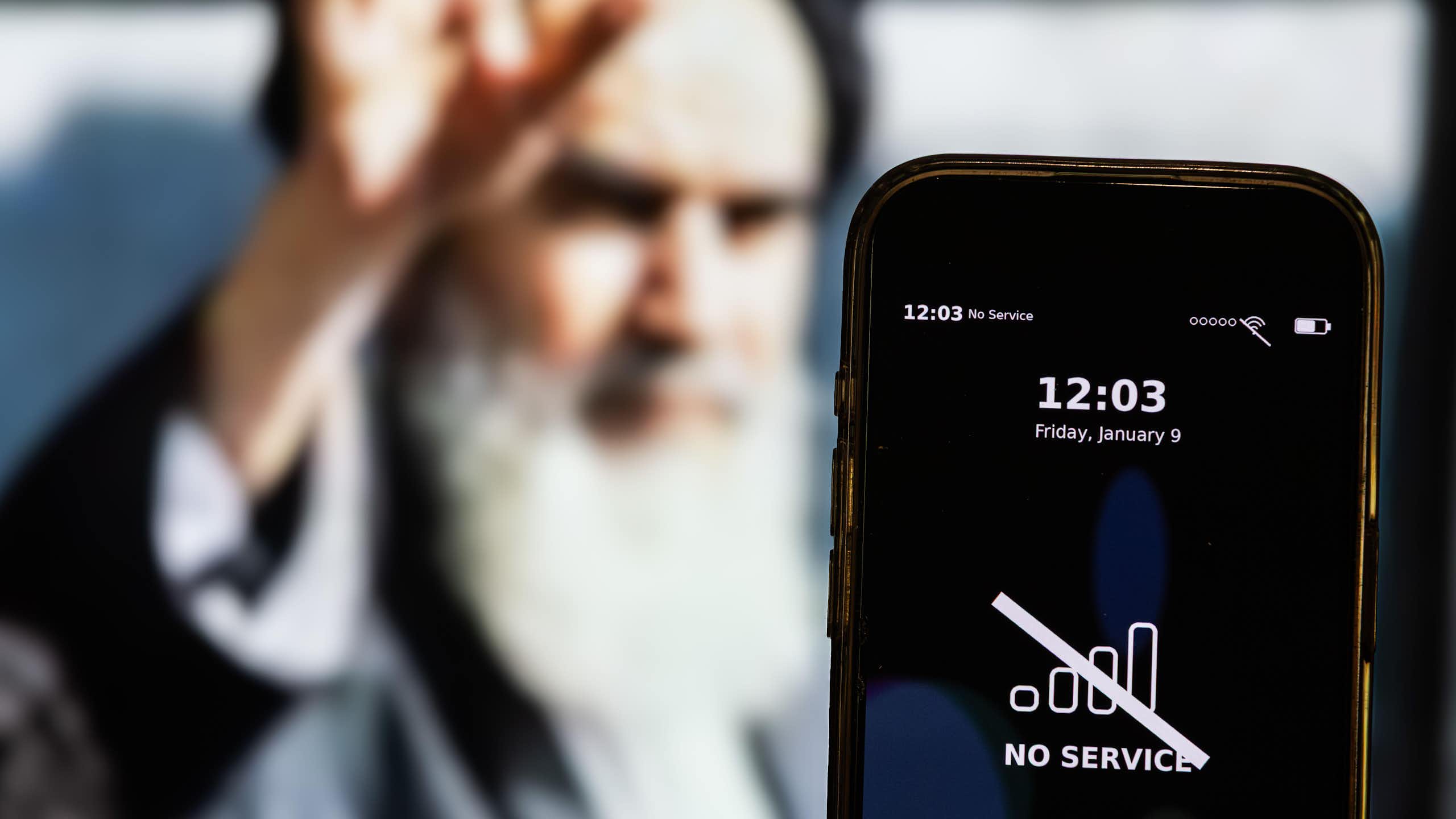 A composite picture showing Iran's supreme leader Ali Khamenei with a smartphone in the foreground with a message about an internet outage.