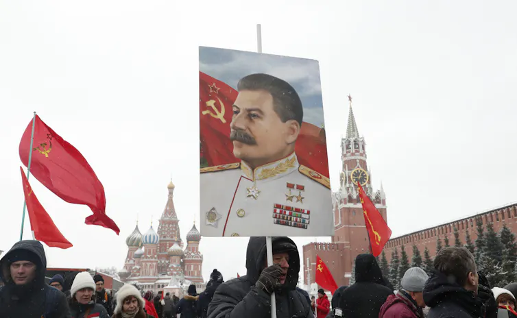 Russian Communist party supporter holds a portrait of Joseph Stalin during a wreath laying ceremony.