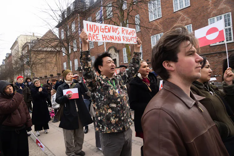 A person carries a placard saying. 'Indigenous rights and human rights' during a demonstration in from of the US embassy in Copenhagen