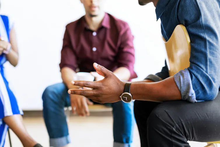 Anonymous men sitting in a circle talking