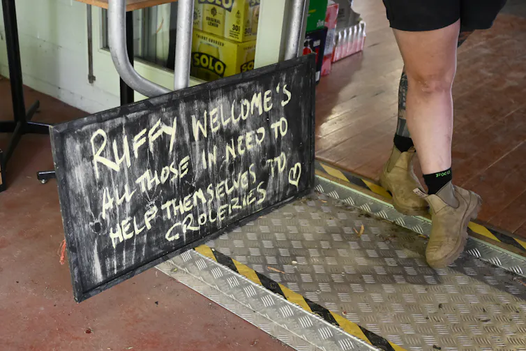 A sign which reads Ruffy welcomes all those in need to help themselves to groceries.