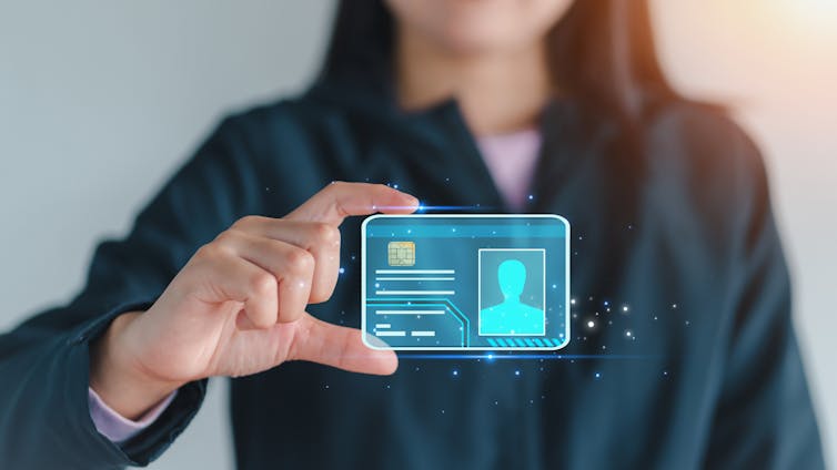A woman appearing to hold a hologram of a digital ID card floating in the air
