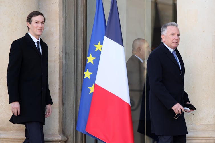 Jared Kusher and Steve Witkoff walk past the French and European Union flags outside a Paris meeting.