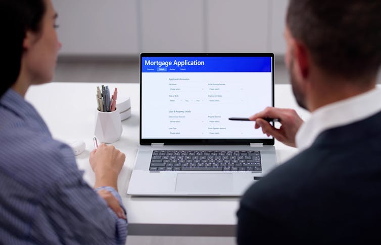 couple sitting in front of laptop filling out online loan application