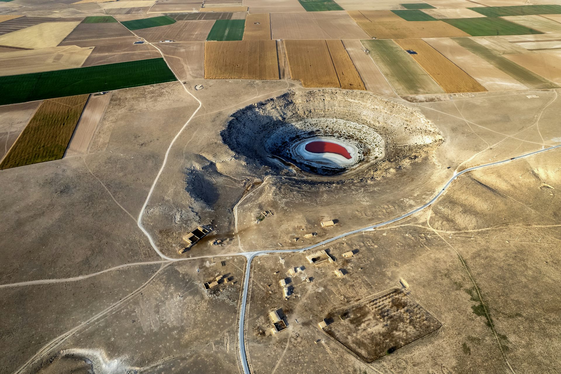 A large sinkhole near farm fields.