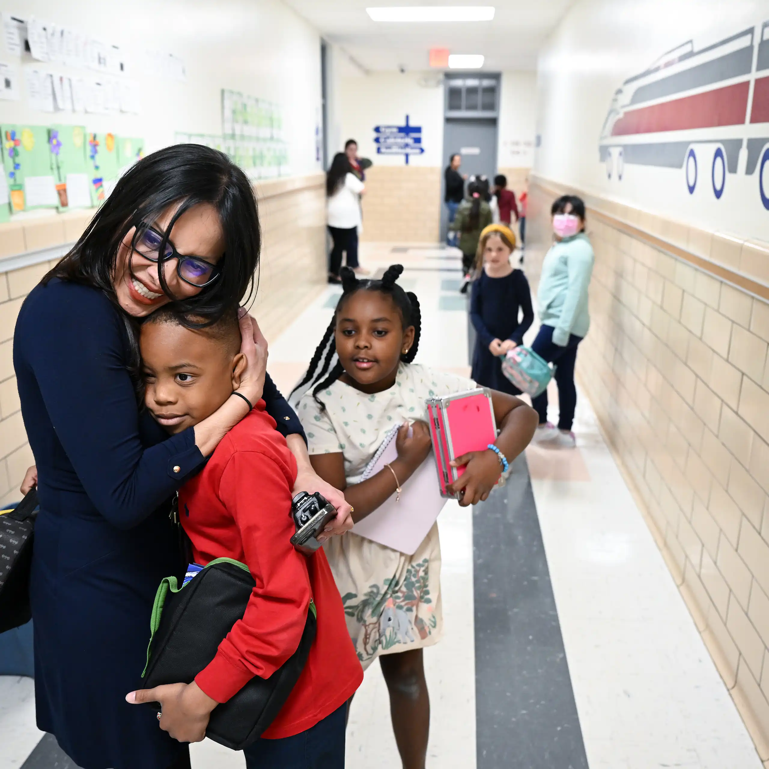 A principal welcomes students to school.