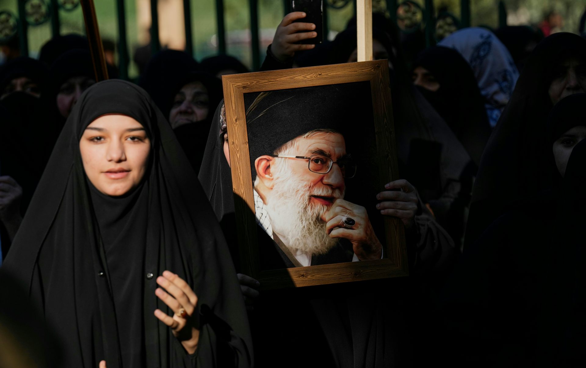 A group of protesters holding a large portrait.