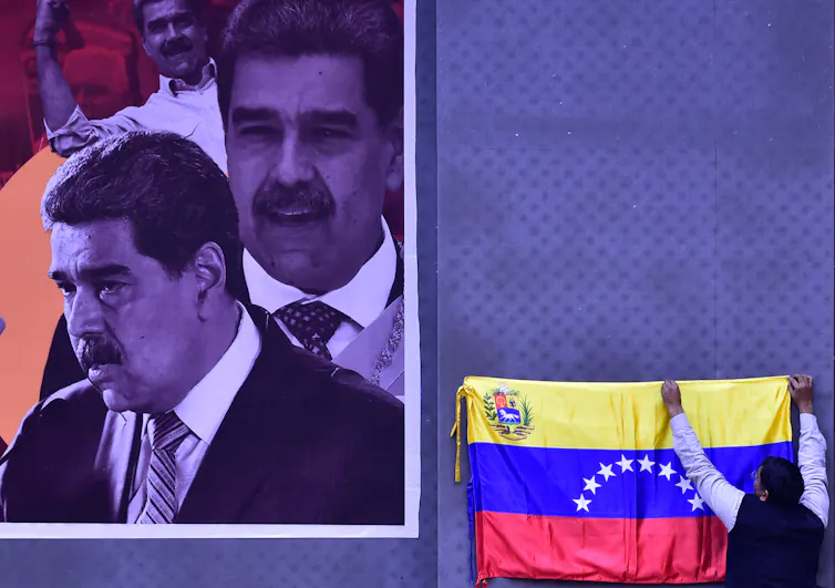 A poster showing a man's face is next to a lectern with a flag on it.