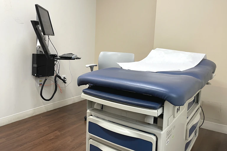 An empty exam room where medical consultations and assessments occur between the patient and doctor.