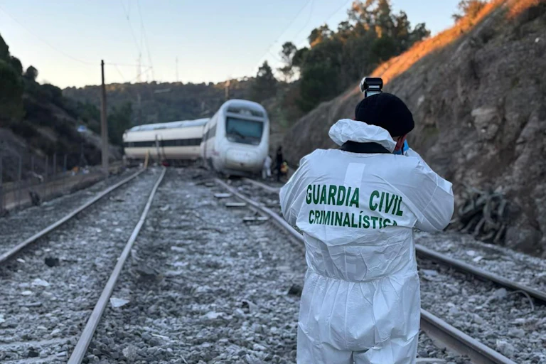 A Spanish Civil Guard officer photographing a derailed train