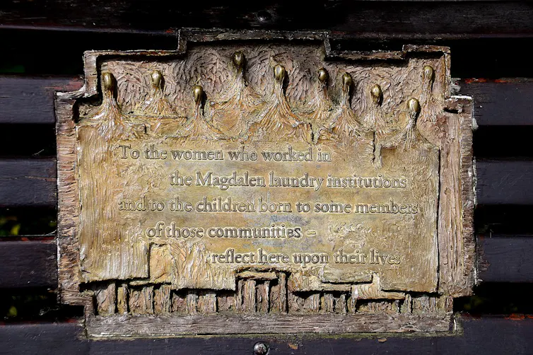 Monumento conmemorativo en un banco a las víctimas de las Lavanderías de la Magdalena en Dublín, en el que se lee: 'A las mujeres que trabajaron en las instituciones de lavandería de Magdalena y a los hijos de algunos miembros de esas comunidades: reflexi
