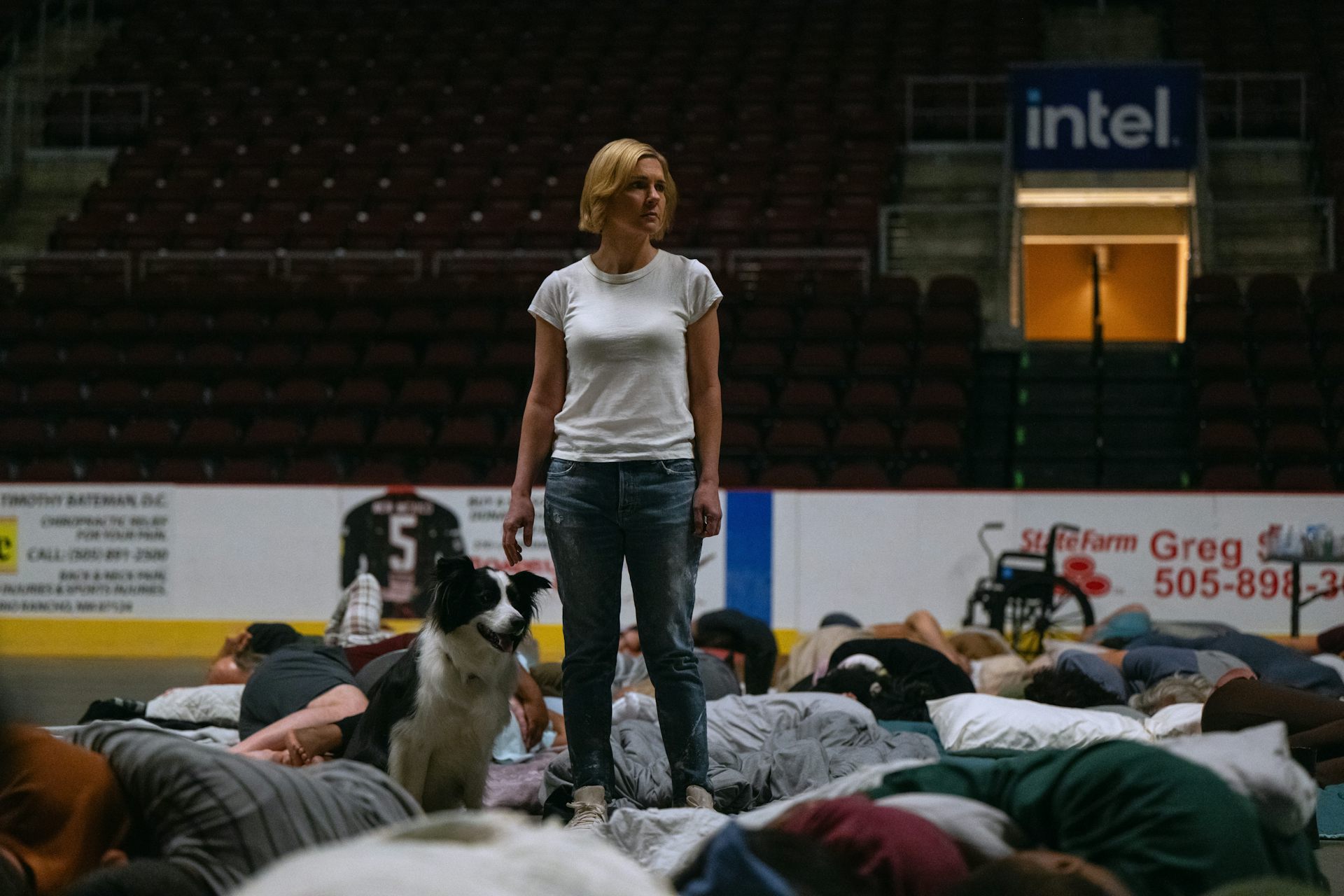 A woman stands among many people lying down.