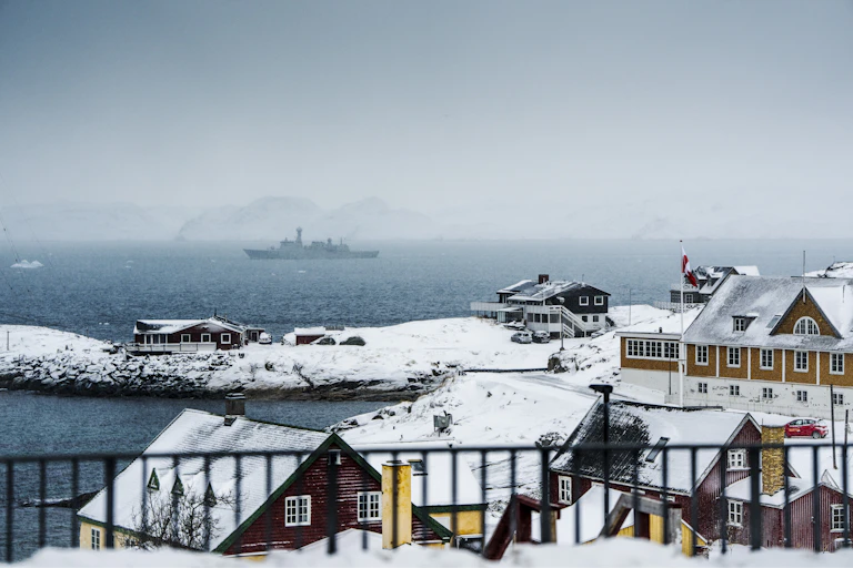 The Greenland coast with a warship in the background.