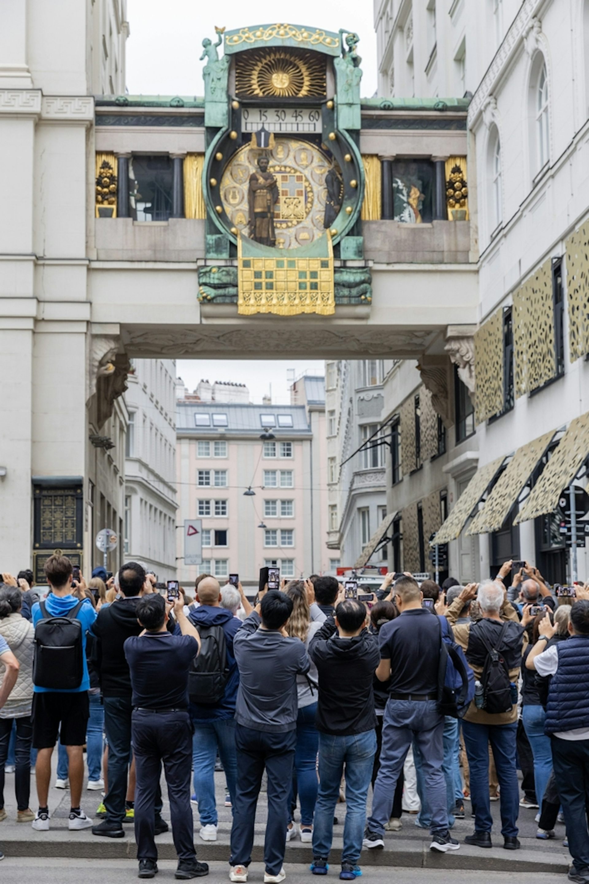 Reloj y mucha gente con teléfonos móviles levantados y mirándolo.