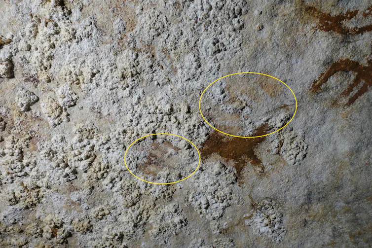 Faint outlines of a hand on a limestone rocky surface.