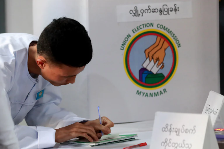 An electoral official signs on the result paper of an electronic voting machine after closing the second phase of the general election at a polling station in Yangon, Myanmar, 11 January 2026