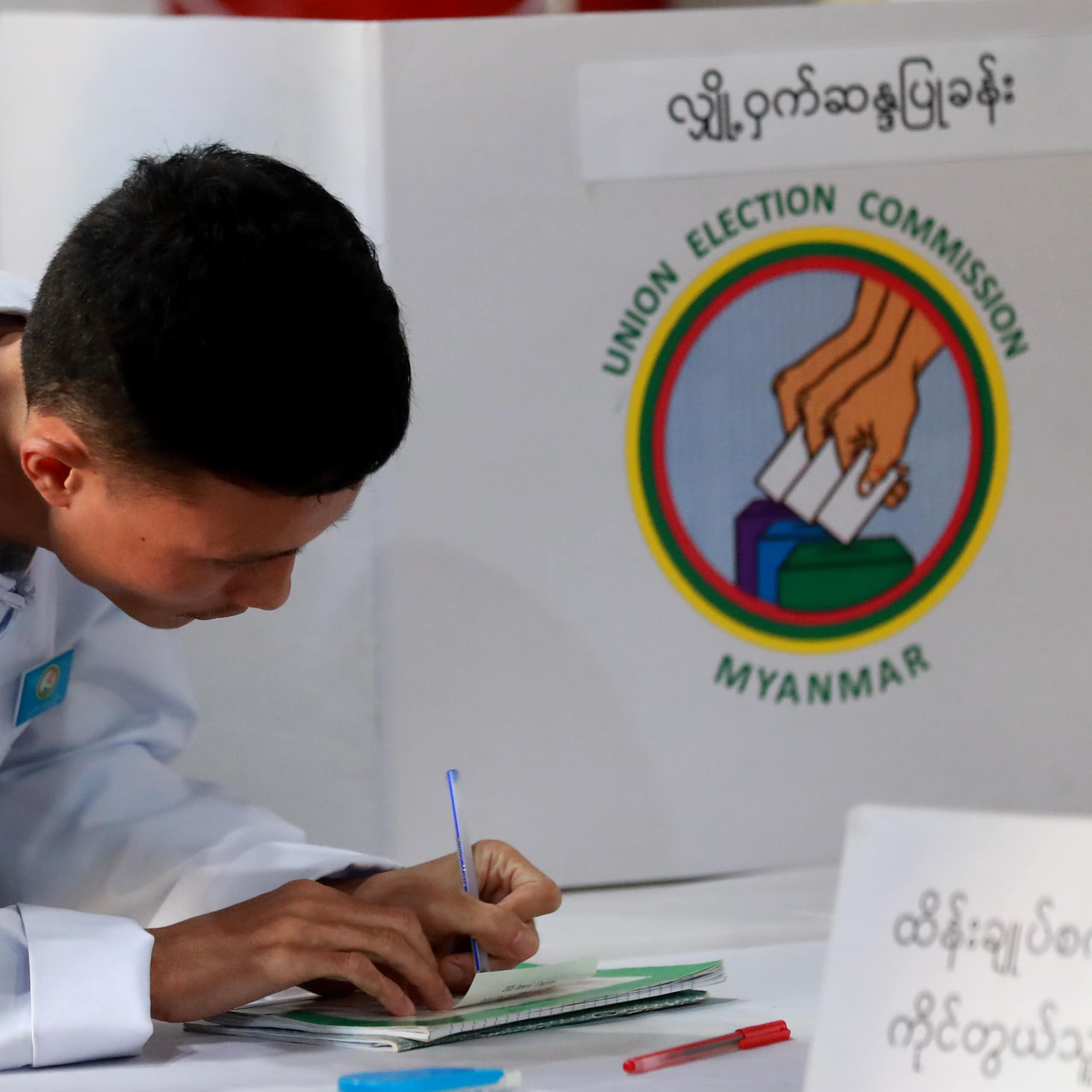 An electoral official signs on the result paper of an electronic voting machine after closing the second phase of the general election at a polling station in Yangon, Myanmar, 11 January 2026